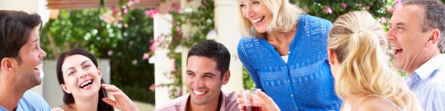 Group Of Young And Senior Couples Enjoying Family Meal