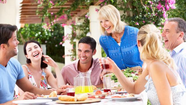 Group Of Young And Senior Couples Enjoying Family Meal